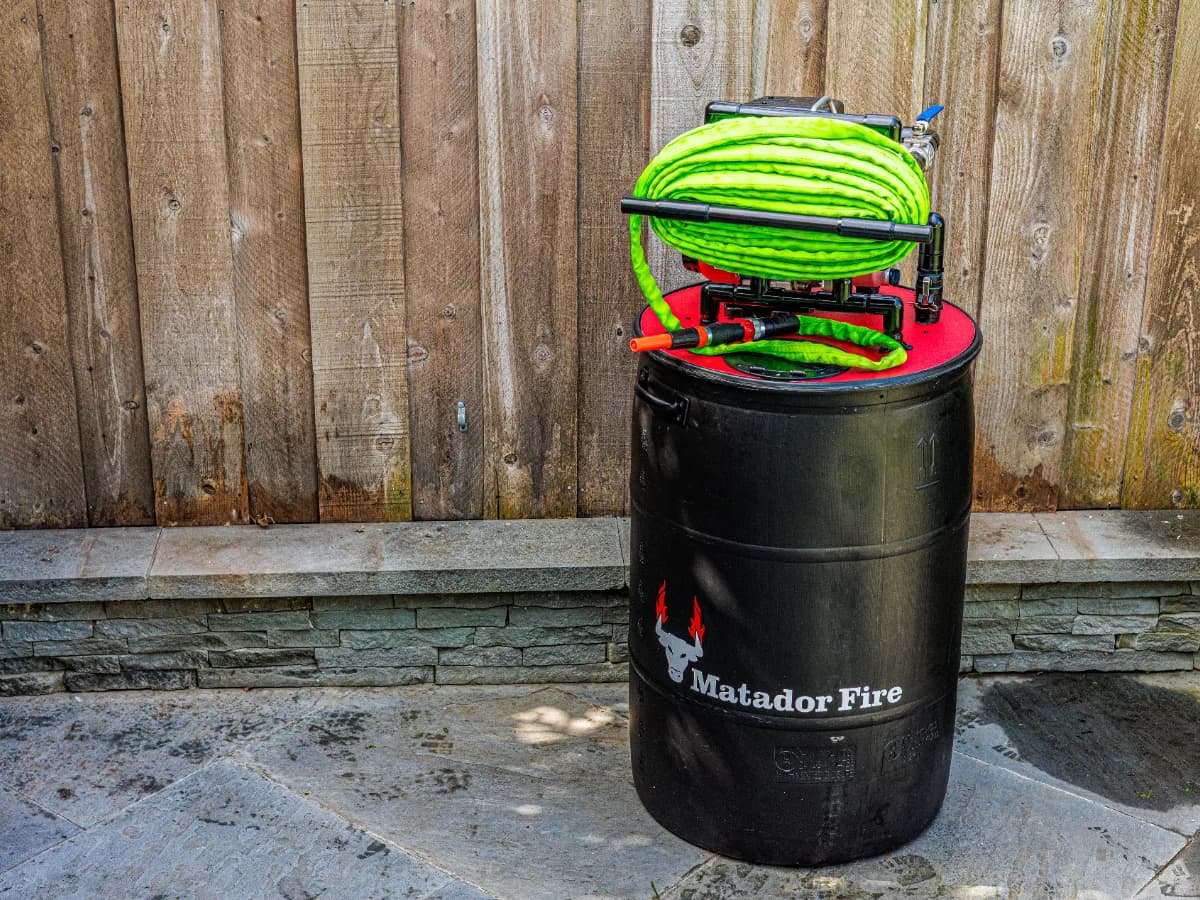 Matador Fire wildfire defense system barrel with hose reel installed at a residential property